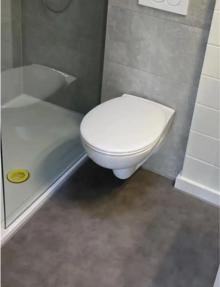 Dezelfde badkamer na de opkuis, met propere vloer en sanitair