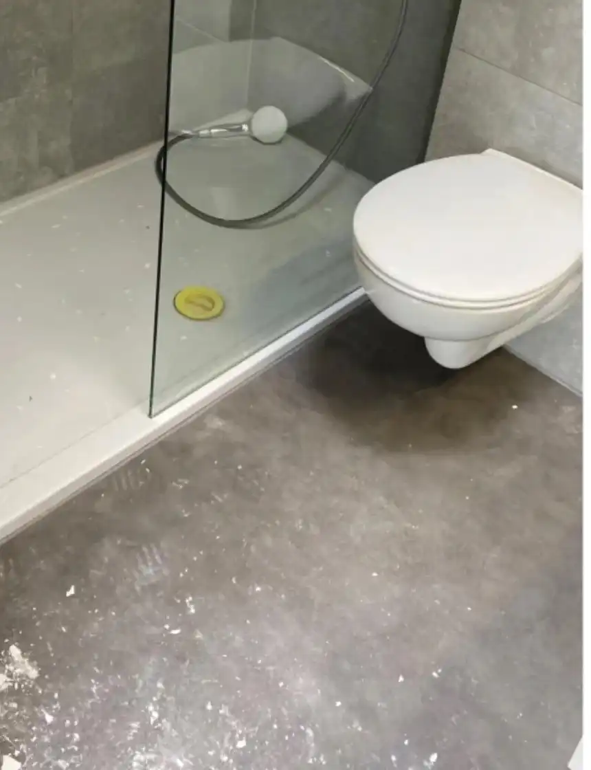 Badkamer vóór de opkuis, met bouwstof en vuil op de vloer